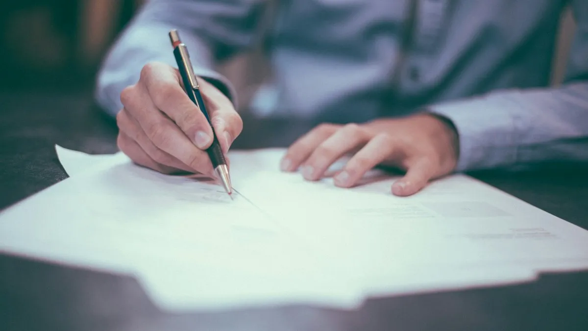Une personne signe un document avec un stylo